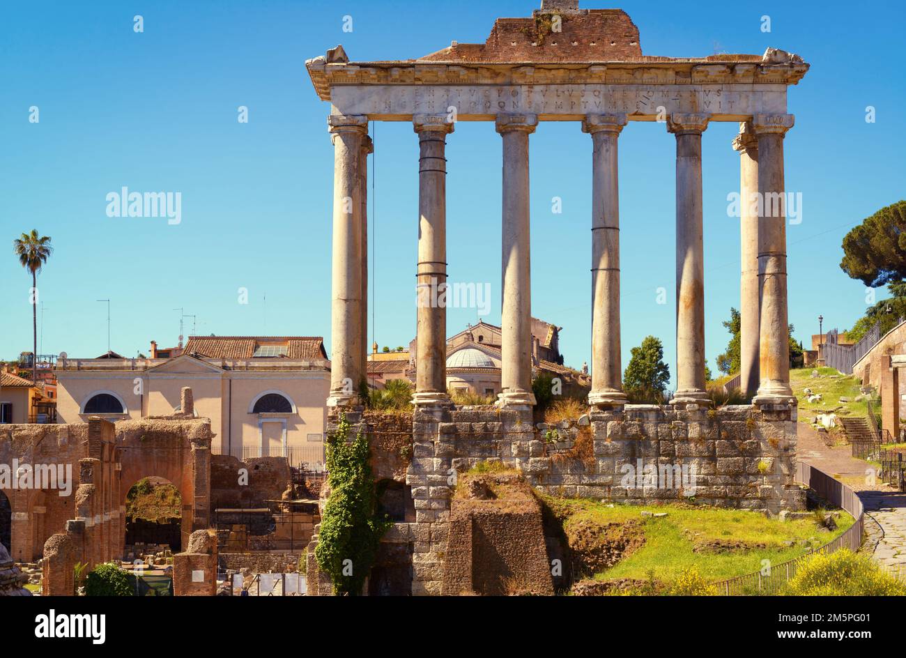 Ancien temple de Saturne dans le Forum romain, Rome, Italie, Europe. C'est un point de repère de Rome. De vieilles colonnes s'élèvent au-dessus des ruines du Forum et des bâtiments de la ville de Roma cen Banque D'Images