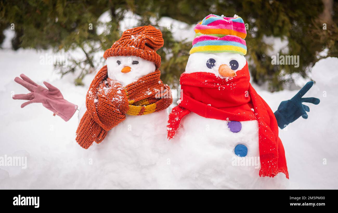 Un couple de bonhommes de neige en chapeaux et foulards.L'hiver s'amuse  Photo Stock - Alamy