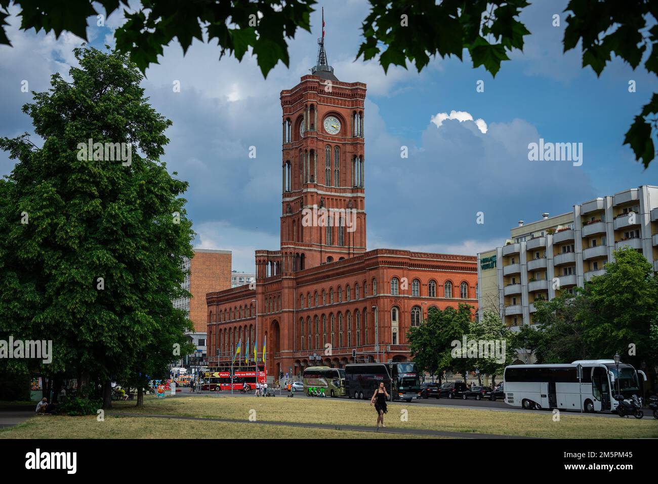 Berlin, Allemagne - 25 juin 2022: Rotes Rathaus, l'hôtel de ville de Berlin tiré du parc Innerstadt avec des bus touristiques en face Banque D'Images