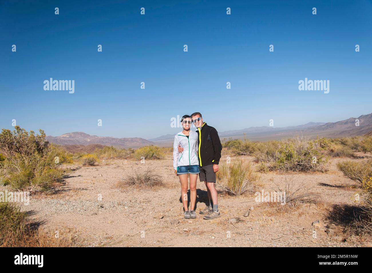 un couple happ biracial dans le paysage désertique du parc national de joshua tree en californie ensoleillée. Banque D'Images