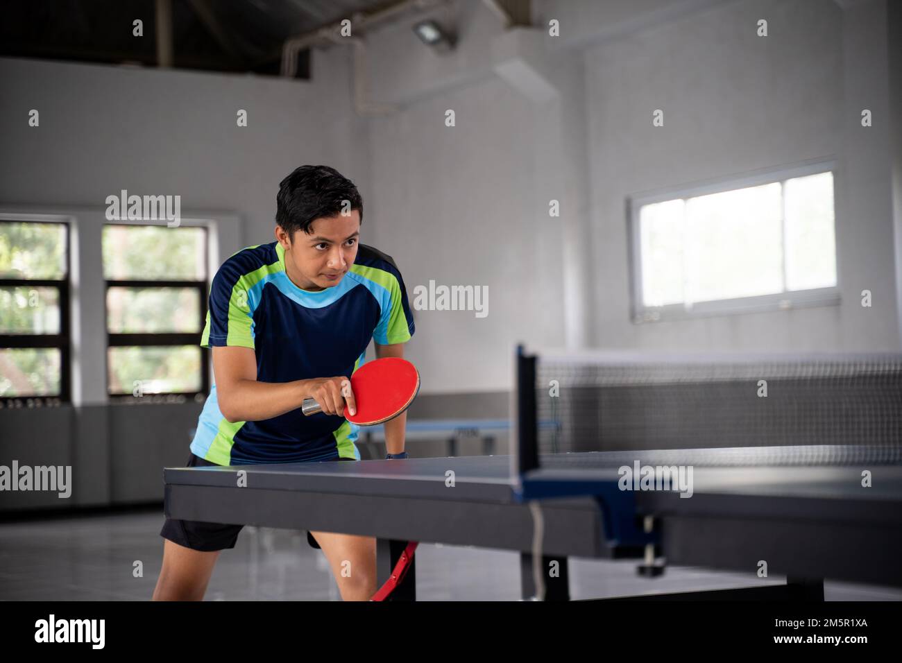 Joueurs de ping-pong asiatiques dans une position prête à affronter la concurrence Banque D'Images