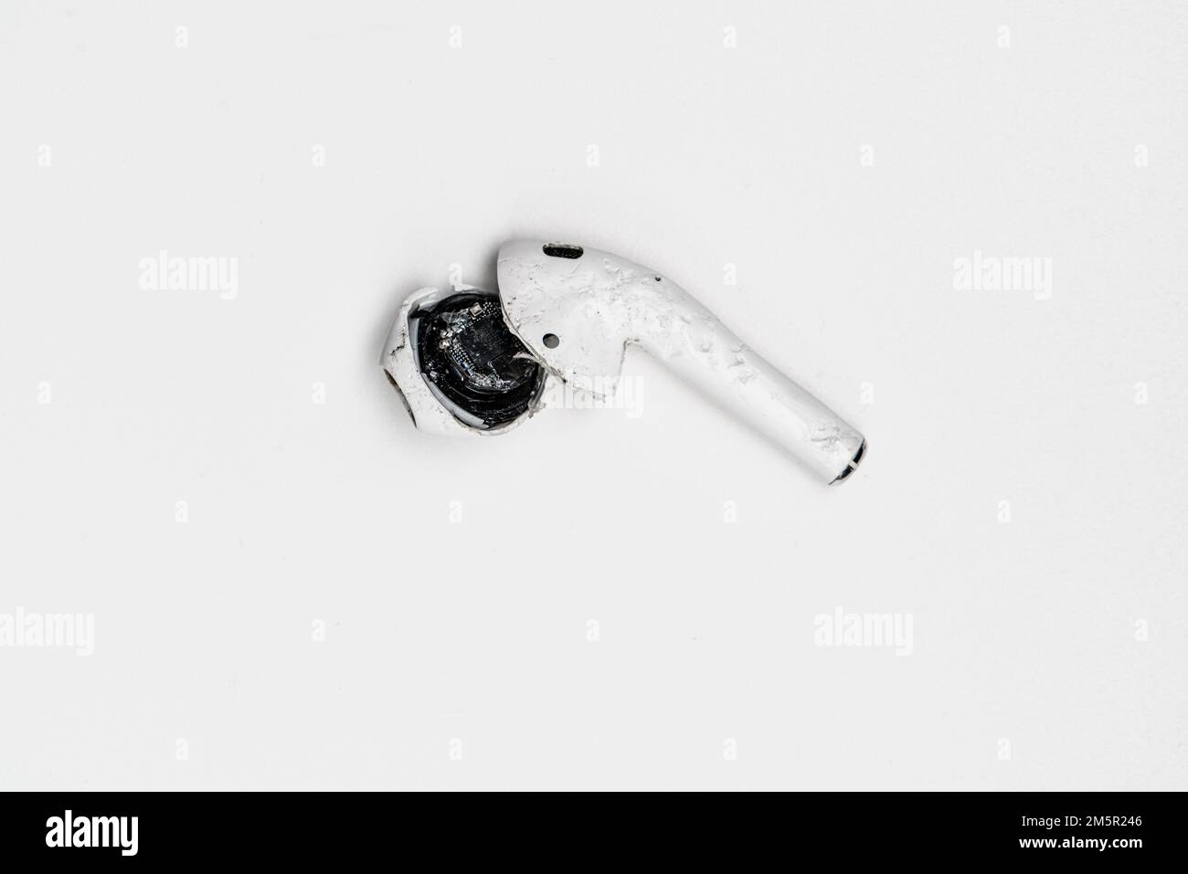 Un AIpod Apple cassé (casque sans fil) est resté sans vie et ne fonctionne pas après qu'il a été écrasé mort. Banque D'Images