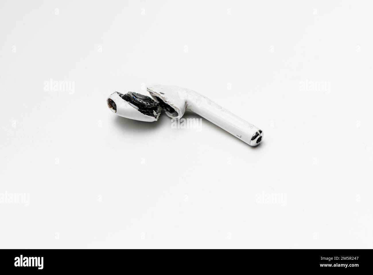 Un AIpod Apple cassé (casque sans fil) est resté sans vie et ne fonctionne pas après qu'il a été écrasé mort. Banque D'Images