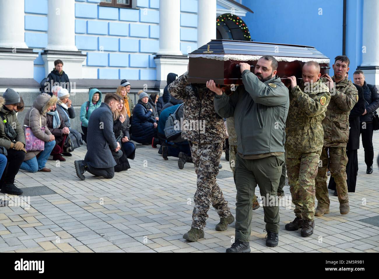 KIEV, UKRAINE - 30 DÉCEMBRE 2022 - les gens s'agenouillent pour montrer leur respect comme militaires portent le cercueil avec le corps de l'ancien prisonnier politique Henna Banque D'Images