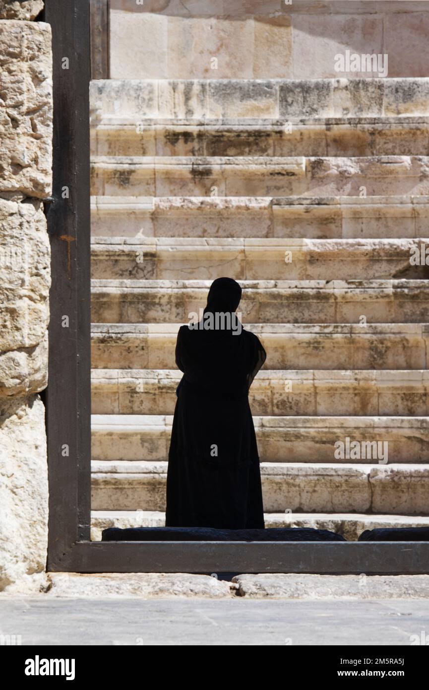 Vue arrière d'une femme arabe vêtue d'une burka noire et d'un voile facial Banque D'Images