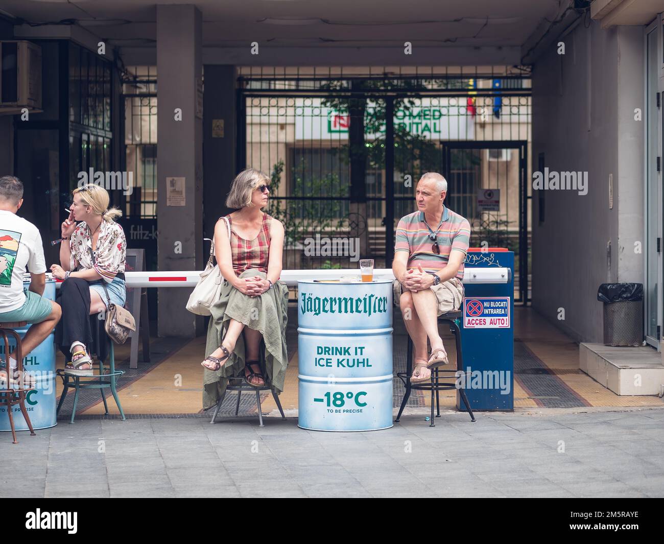 Bucarest, Roumanie - août 2022 : scène urbaine avec un couple d'âge moyen assis à une table et prenant une bière dans la vieille ville de Buchares. Banque D'Images