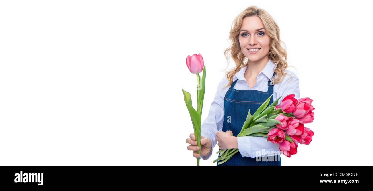 Jeune femme heureuse en tablier avec fleurs de tulipe de printemps isolées sur fond blanc, femme isolée visage portrait, bannière avec maquette copie espace. Banque D'Images