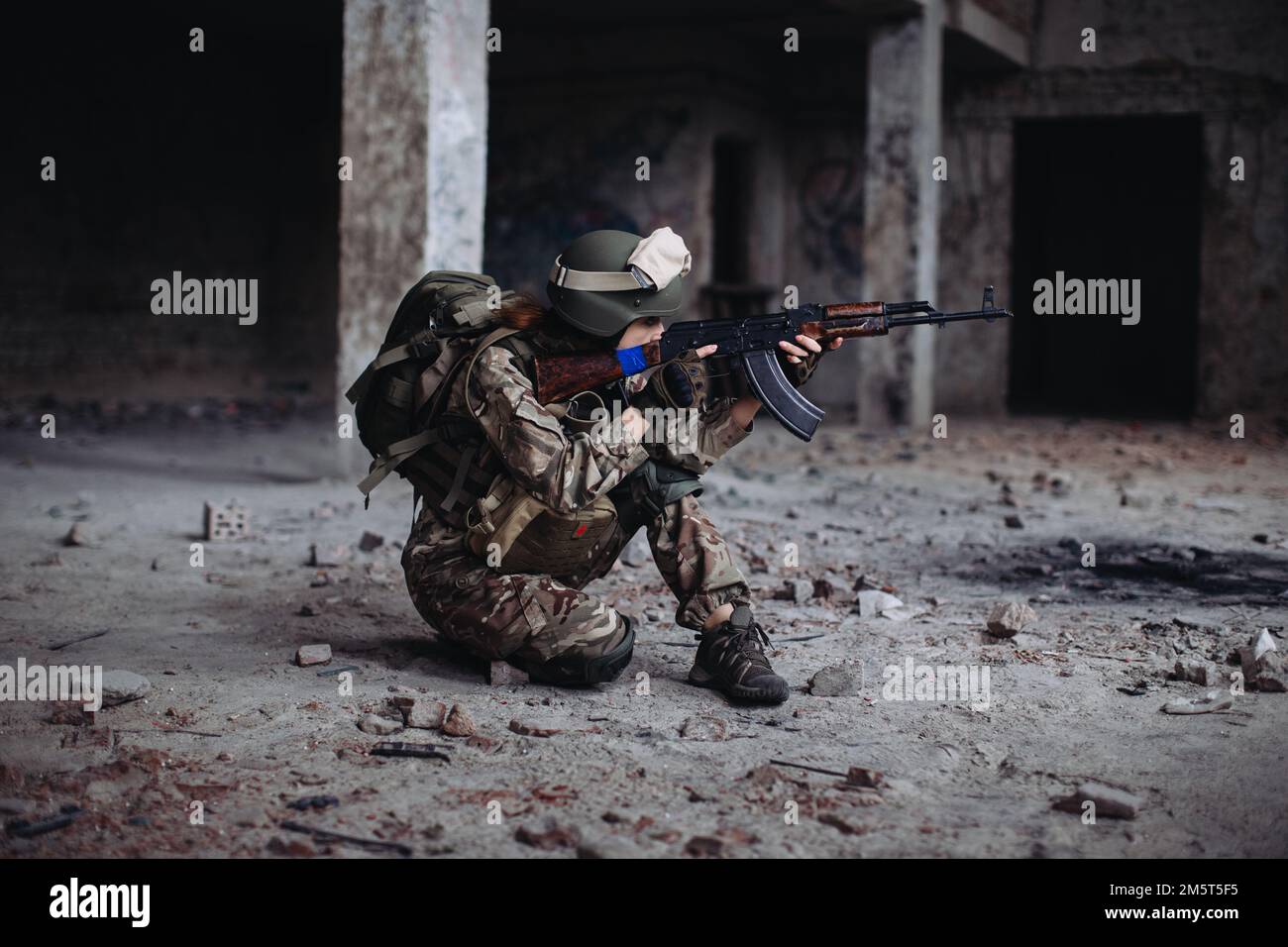 Femme ukrainienne Soldat avec une arme dans ses mains dans un bâtiment détruit. Guerre entre l'Ukraine et la Russie. Banque D'Images