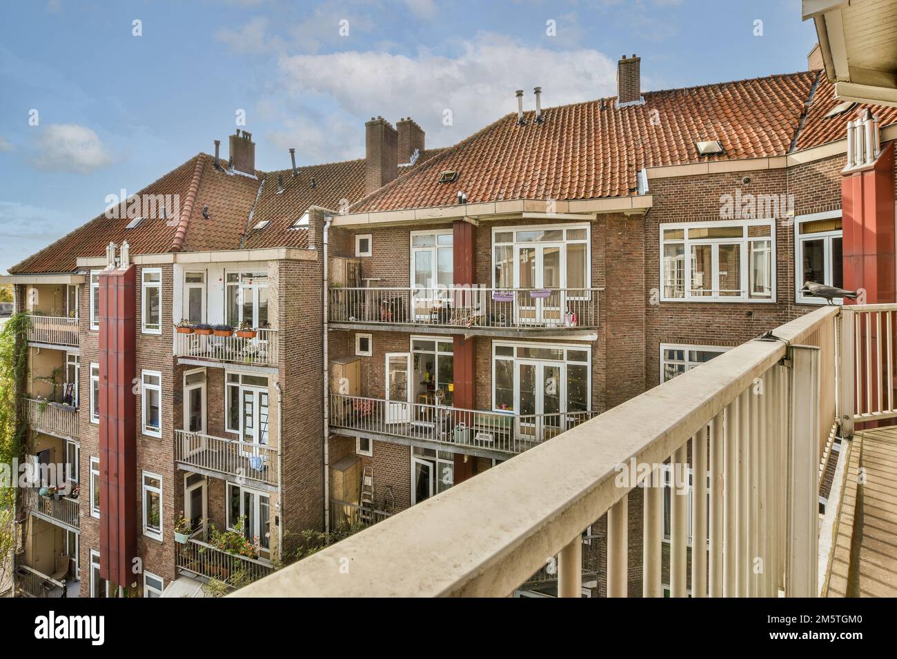 quelques maisons de la ville avec des volets rouges et des madriers blancs sur leurs fenêtres, prises d'un balcon d'appartement Banque D'Images