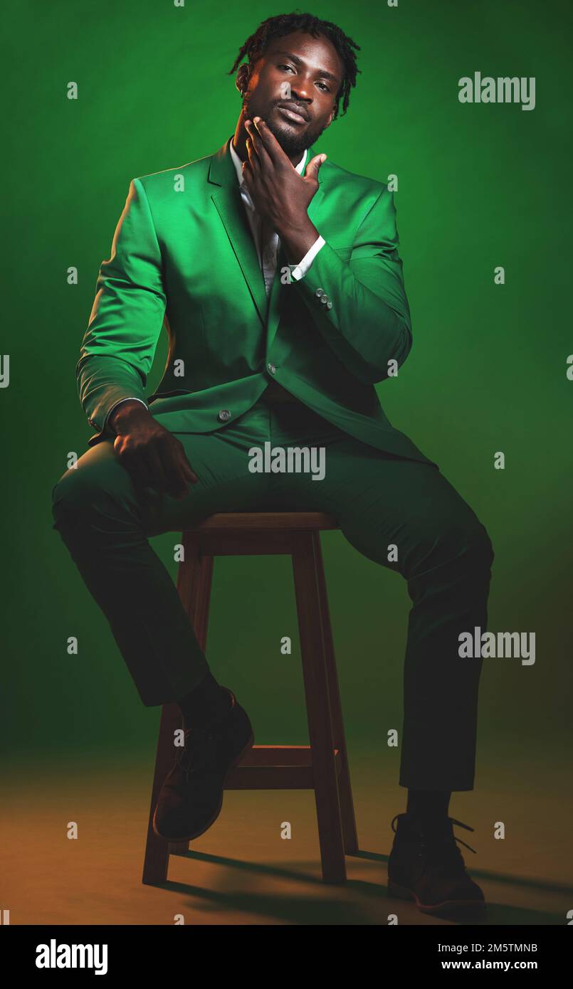 Mode, formel et portrait d'un homme noir en costume assis sur une chaise en studio avec une tenue de luxe. Élégant, élégant et modèle africain avec Banque D'Images
