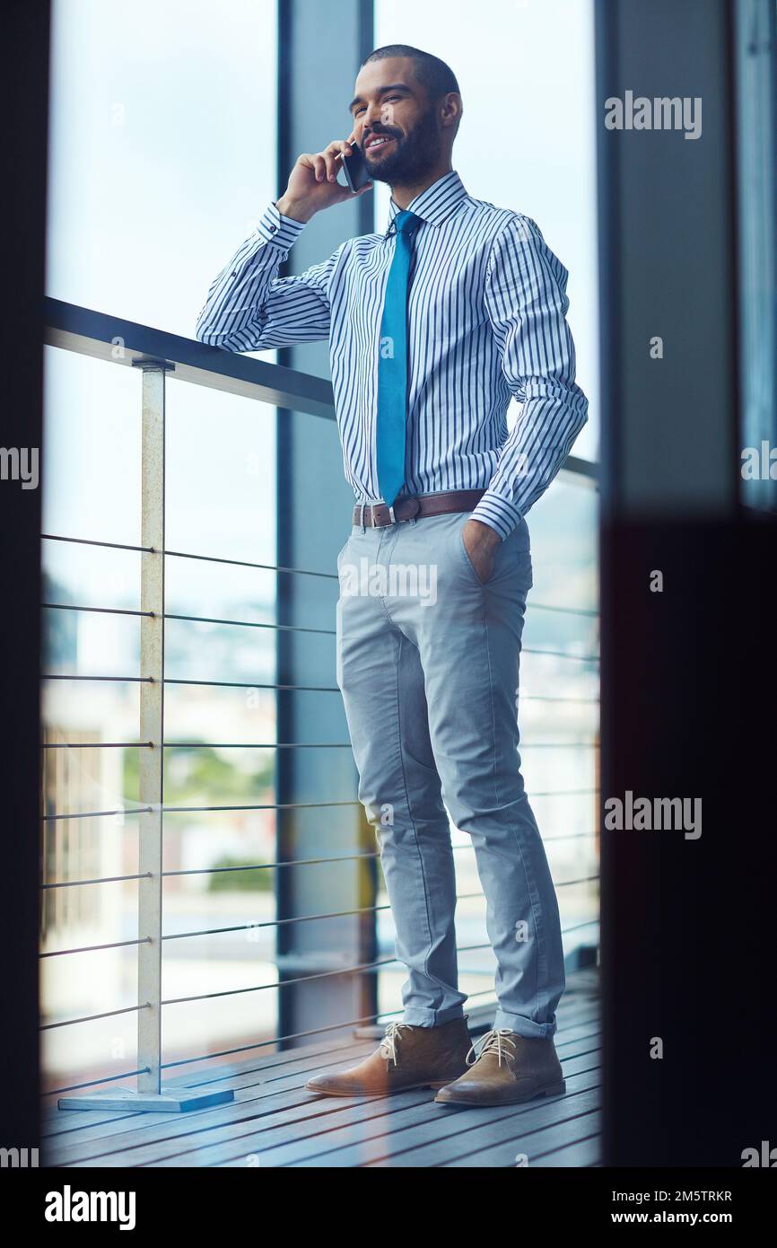 Organiser une réunion avec un client. un jeune homme d'affaires parlant au téléphone au bureau. Banque D'Images