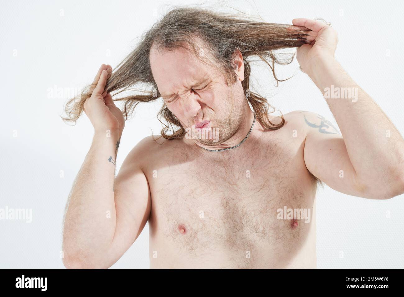 Homme en colère contre ses longs cheveux Banque D'Images