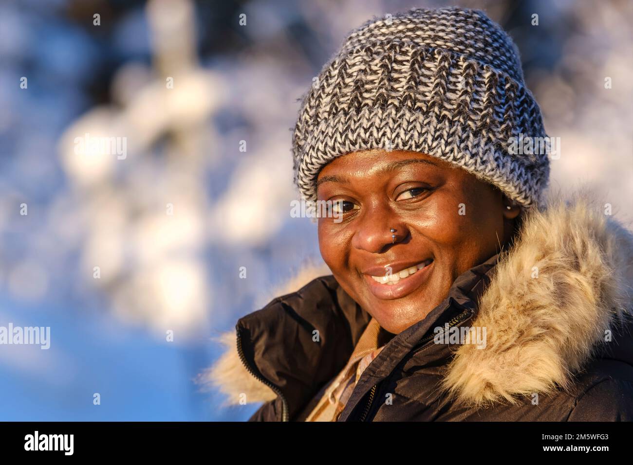 Femme africaine dehors pendant une journée d'hiver ensoleillée dans la nature suédoise. Banque D'Images