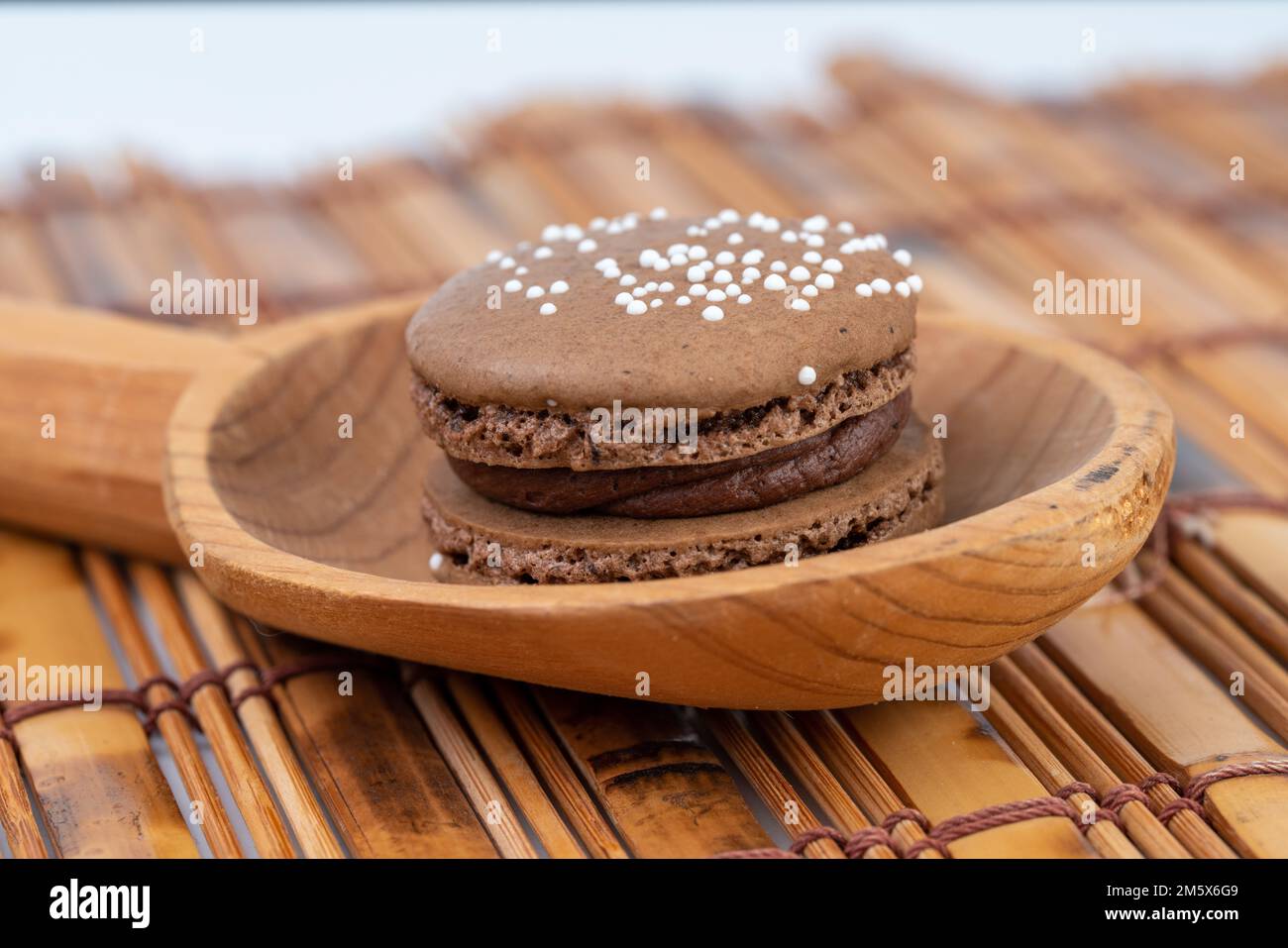 Le chocolat macron servi sur une cuillère en bois Banque D'Images