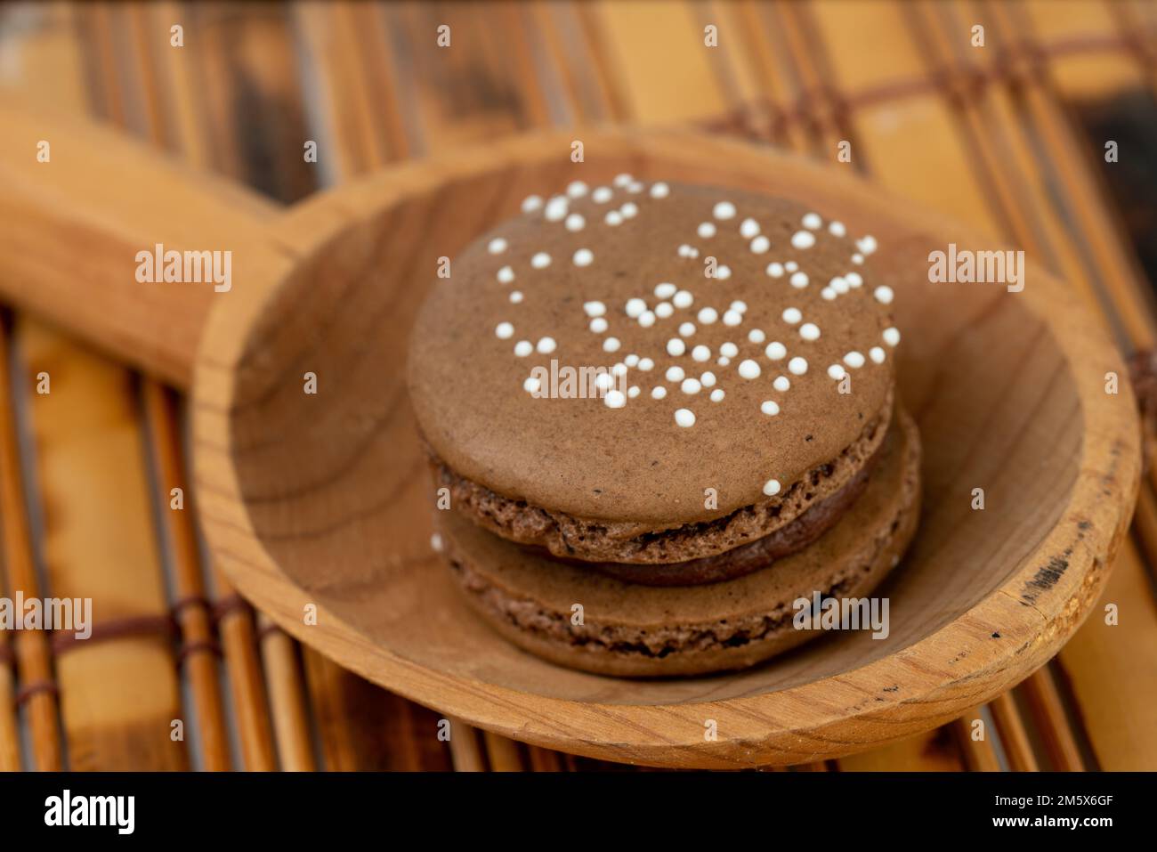 Le chocolat macron servi sur une cuillère en bois Banque D'Images