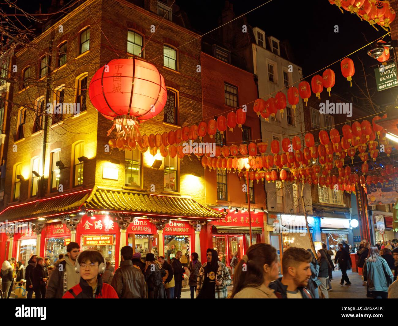 Une vue sur Gerrard Street occupé la nuit dans le quartier chinois de Londres décoré de lanternes rouges suspendues Banque D'Images