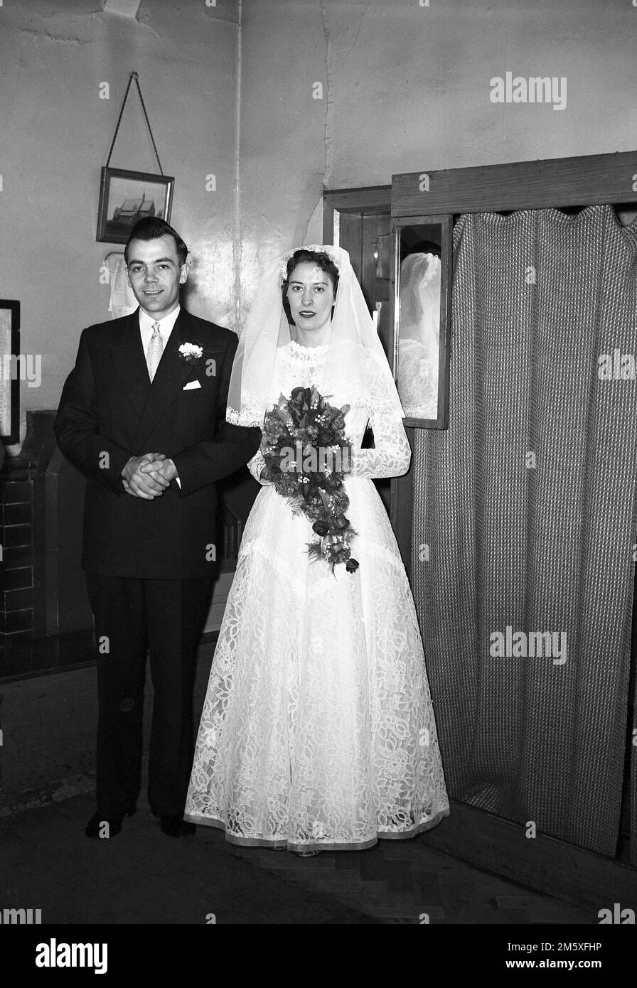 1950, historique, un couple juste marié debout dans une sacristie d'une église pour une photo, Angleterre, Royaume-Uni. Banque D'Images