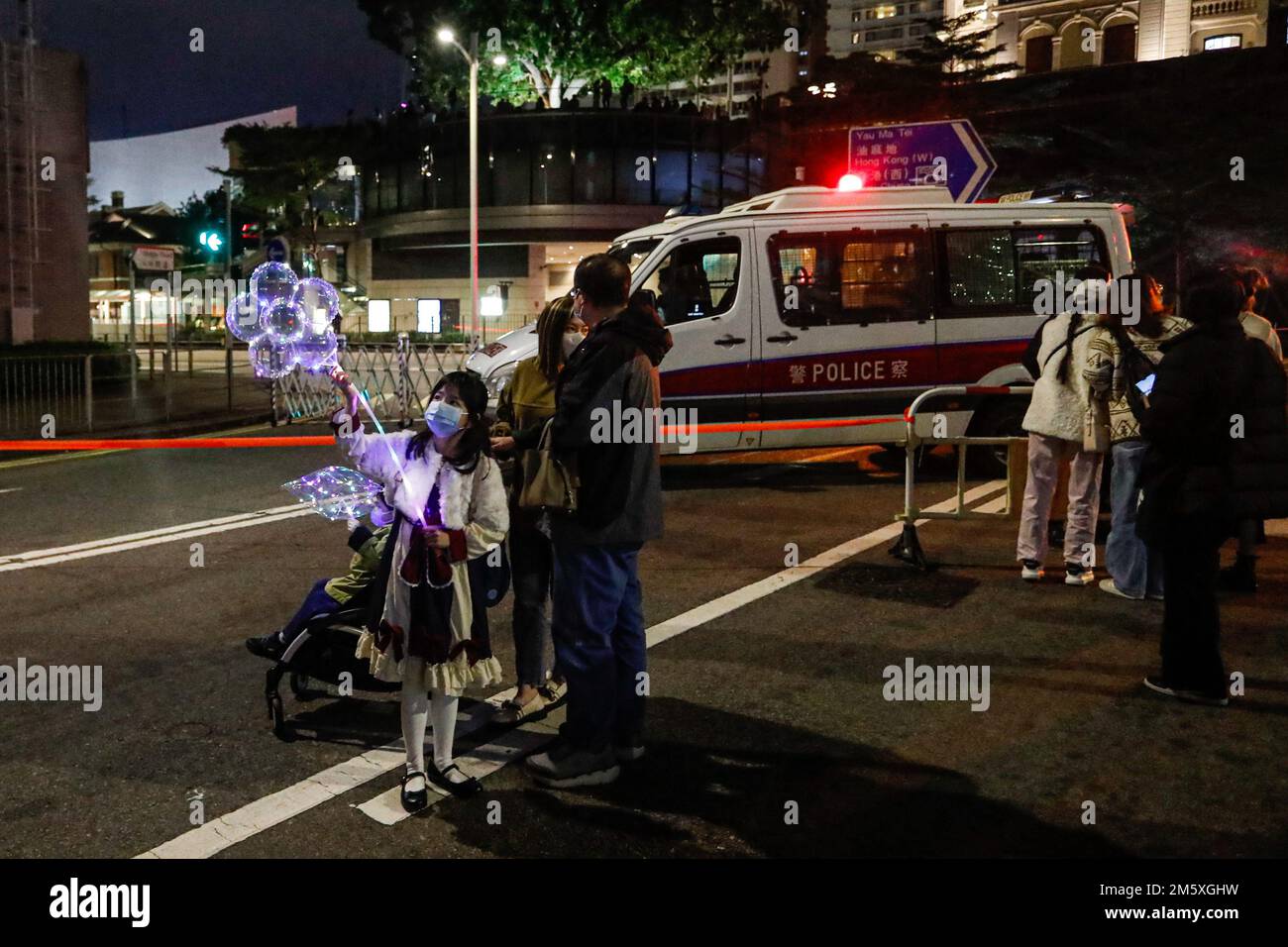 Hong Kong, Hong Kong, Chine. 31st décembre 2022. Une jeune fille tenant un ballon à fleurs LED participe aux célébrations de la Saint-Sylvestre avec sa famille alors que la police de Hong Kong est déployée pour contrôler les foules, après que le gouvernement a annoncé la détente des mesures anti Covid. (Credit image: © Daniel CEng Shou-Yi/ZUMA Press Wire) Credit: ZUMA Press, Inc./Alamy Live News Banque D'Images