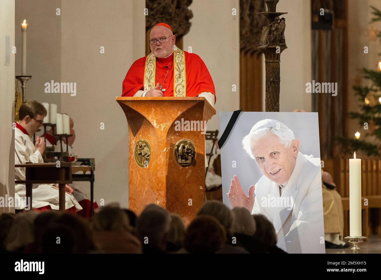 Munich, Allemagne. 31st décembre 2022. L'archevêque Reinhard le cardinal Marx s'exprime à Liebfrauendom à Munich lors de la messe du nouvel an, à côté d'une photo du regretté Pape émérite Benoît XVI, décédé le 31 décembre 2022 au Vatican à l'âge de 95 ans. Crédit : Lennart Preiss/dpa/Alay Live News Banque D'Images