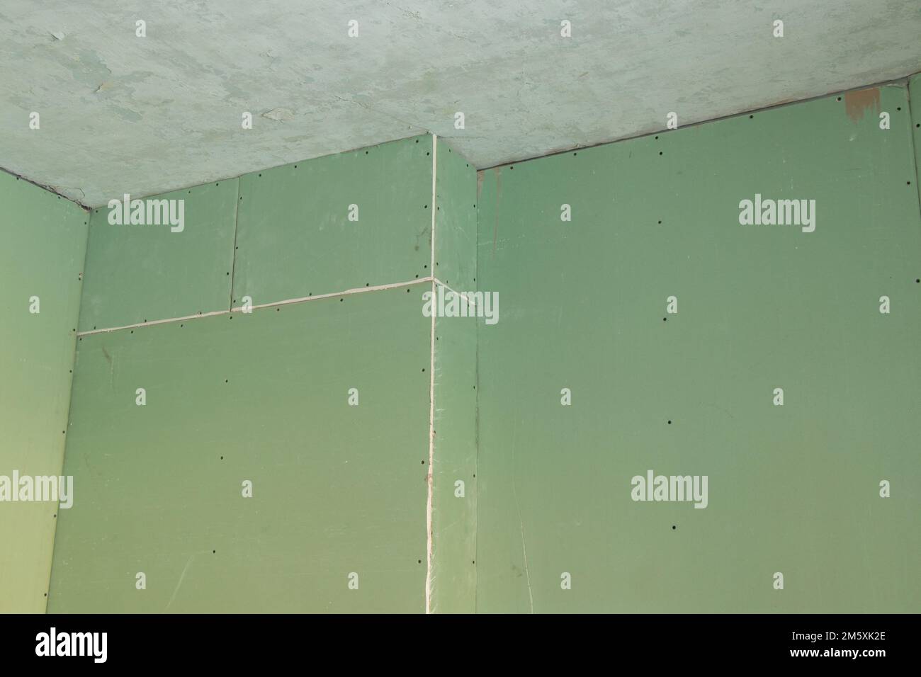 mur en plaques de plâtre vert dans une pièce pendant la rénovation, rénovation d'un appartement, en plaques de plâtre comme arrière-plan, rénovation d'un appartement Banque D'Images