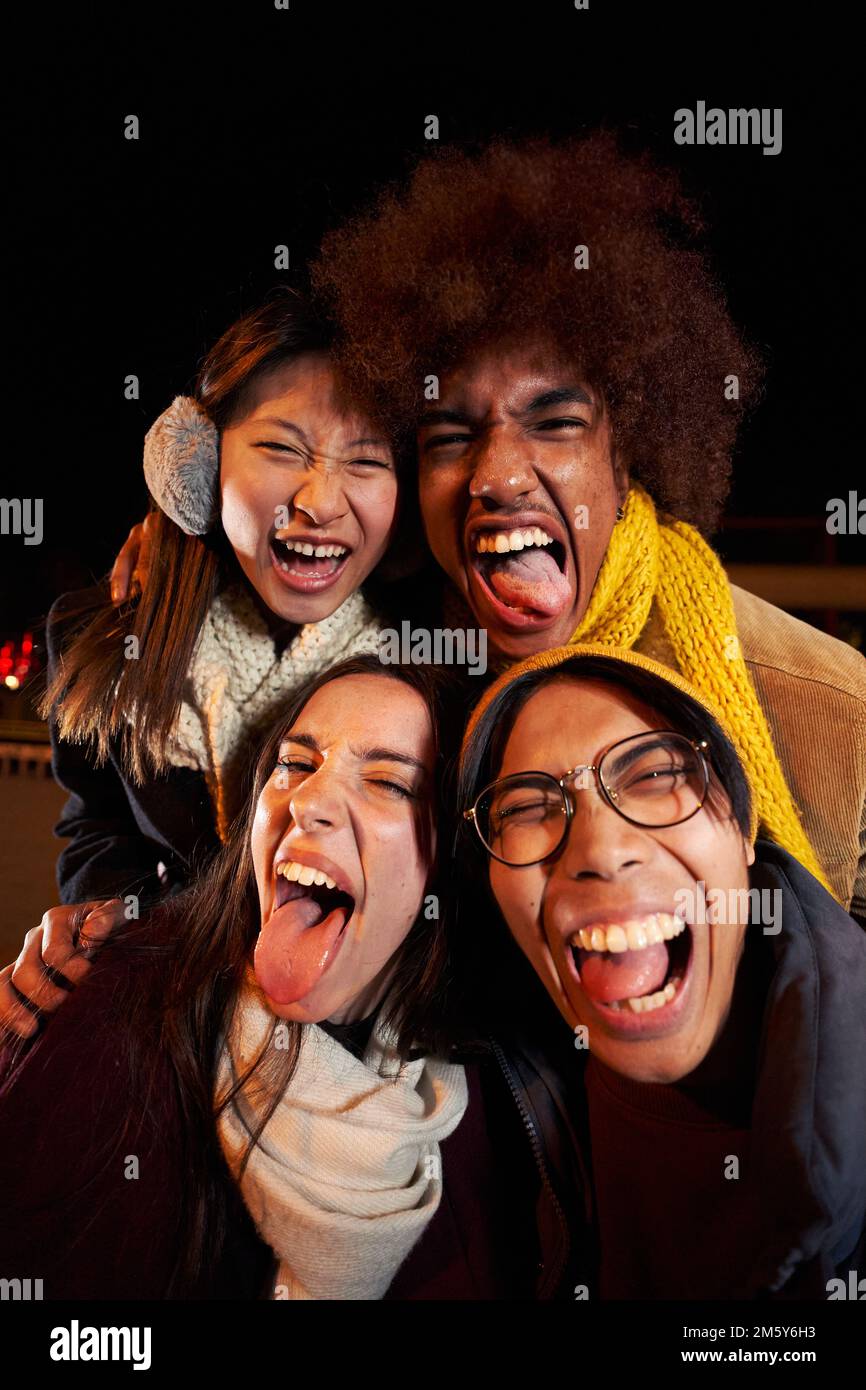 Selfie vertical d'un groupe de personnes heureux prenant photo selfie tout autour dans la nuit Banque D'Images