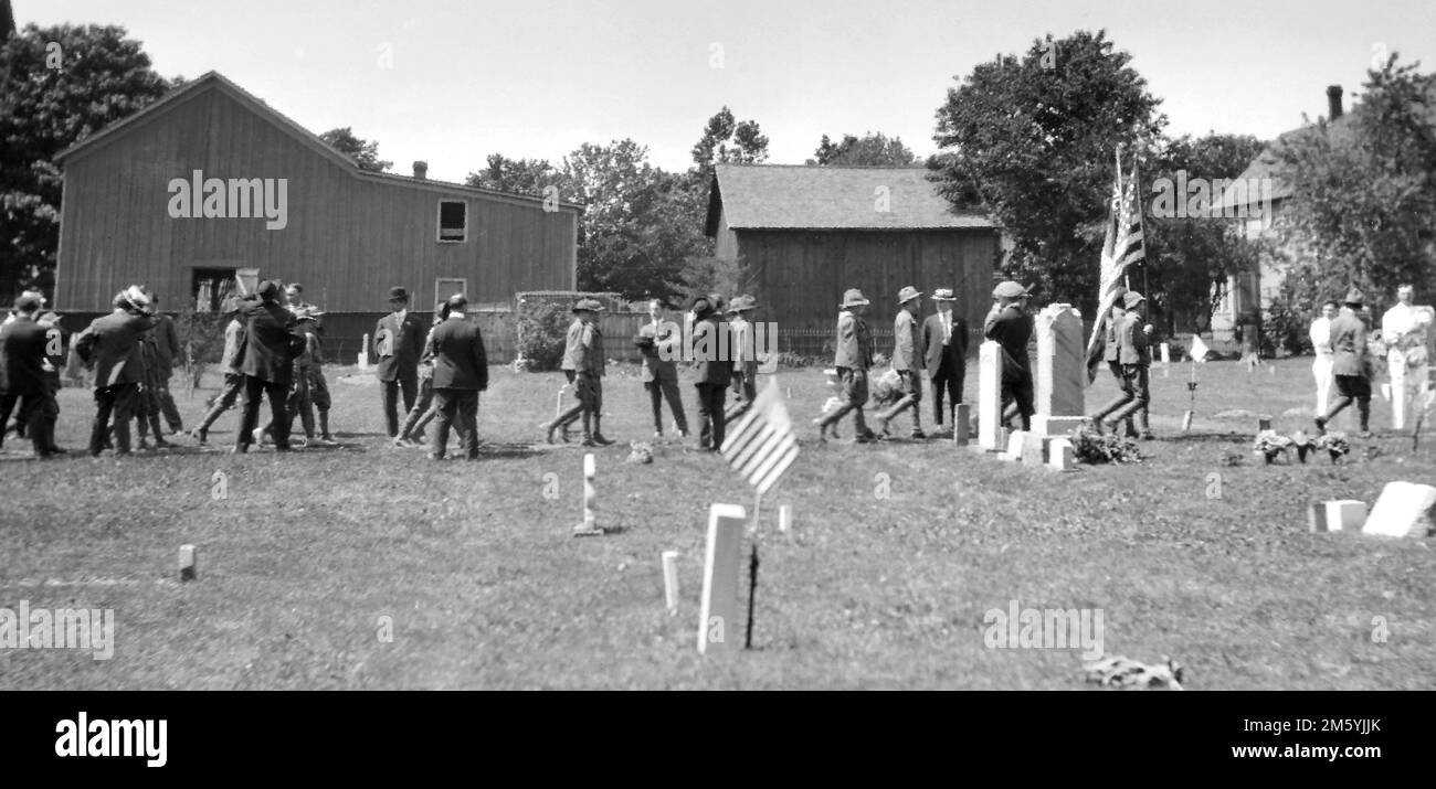 Les vestiges de la petite parade du Memorial Day se terminent dans le cimetière local, ca. 1915. Banque D'Images