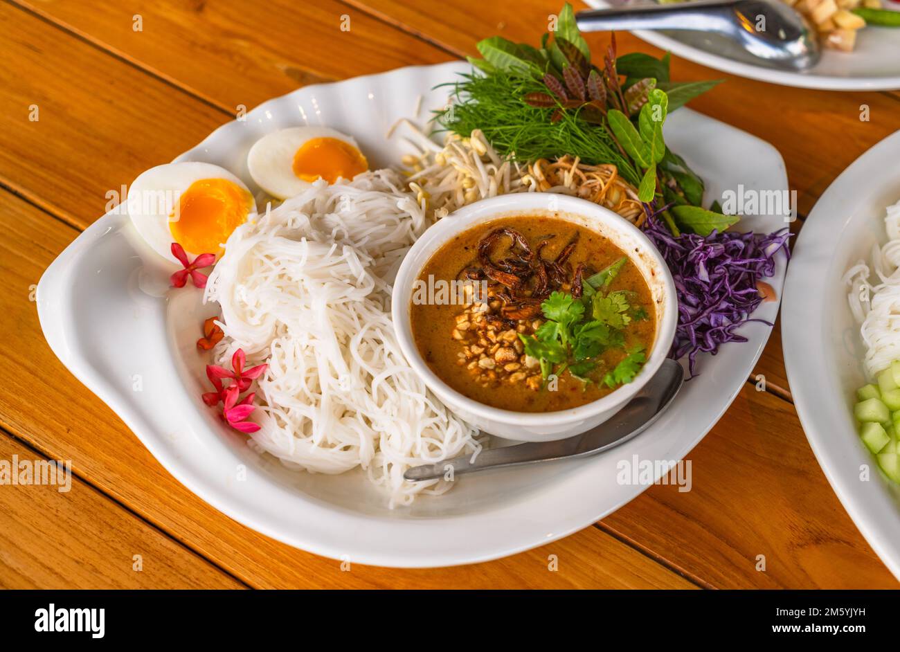 Vermicelles thaïlandaises ou nouilles de riz au curry de sauce aux arachides, accompagnement de légumes biologiques et d'œufs durs. Vermicelles thaïlandaises ou nouilles de riz thaïlandaises au cu Banque D'Images