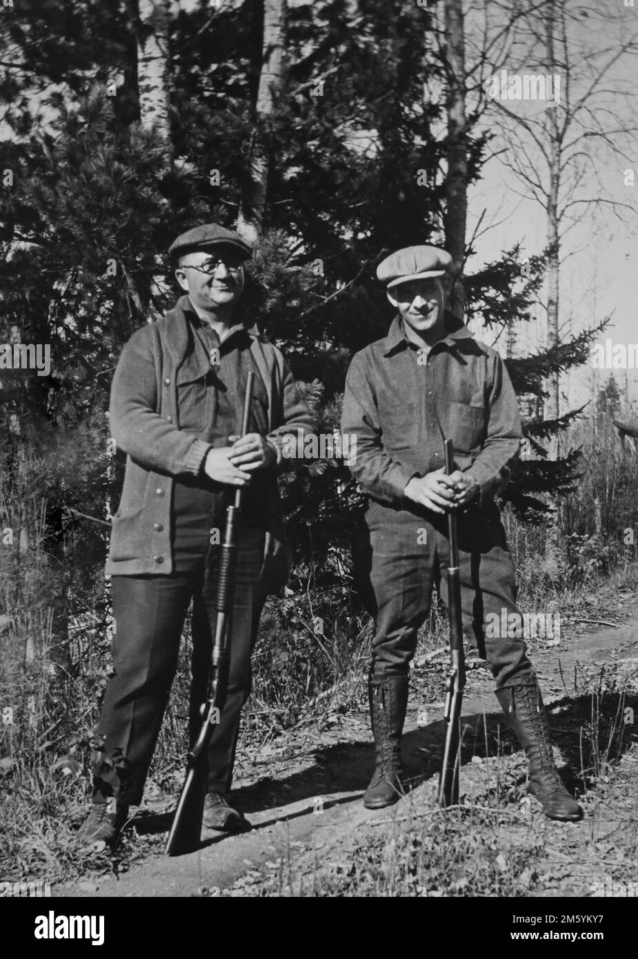Deux chasseurs posent avec leurs armes à feu dans le Wisconsin North Woods, vers 1935. Banque D'Images