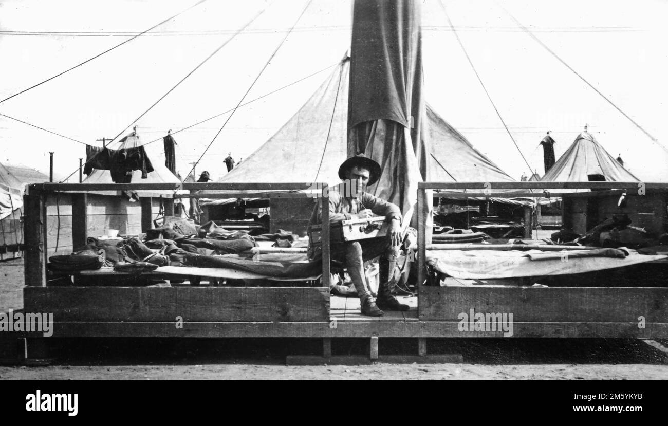 Guerre mondiale 1 soldat américain c. 1917 écrit une lettre assise sur sa plate-forme de tente au camp d'entraînement au Texas. Banque D'Images