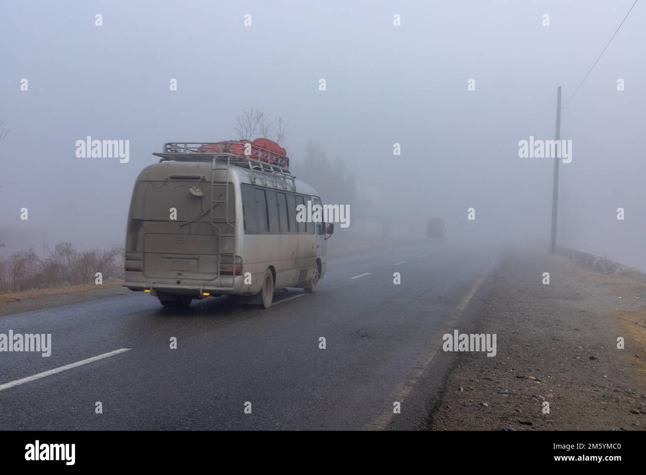 Bus dans un temps brumeux avec une faible visibilité sur une route dans la vallée de swat, Pakistan Banque D'Images