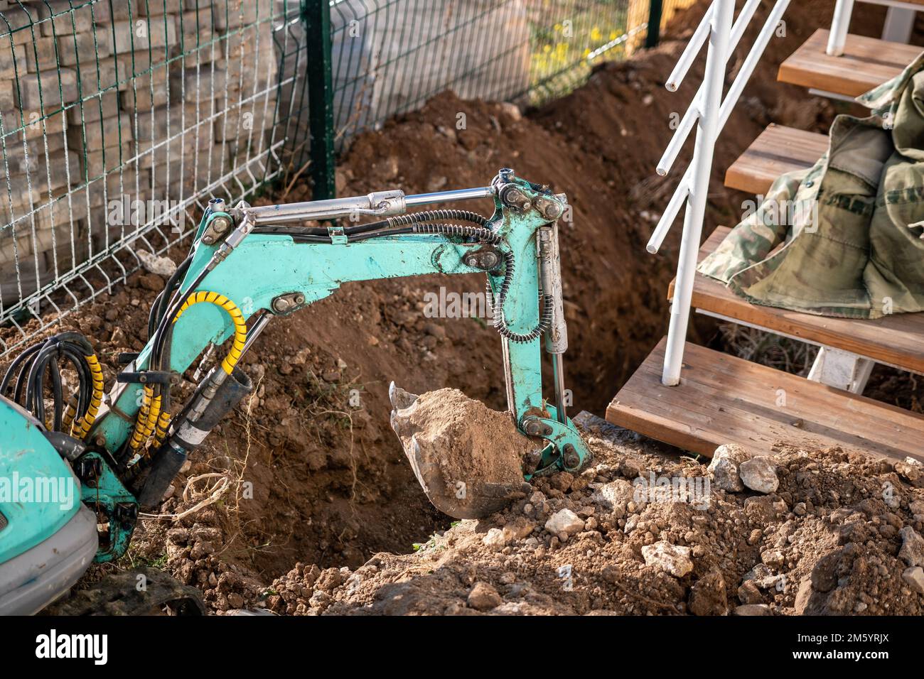 Une minipelle creuse une tranchée pour poser les tuyaux. Gros plan d'une pelle hydraulique creusant une tranchée profonde. Une pelle hydraulique creuse une tranchée dans la campagne pour déposer un Banque D'Images