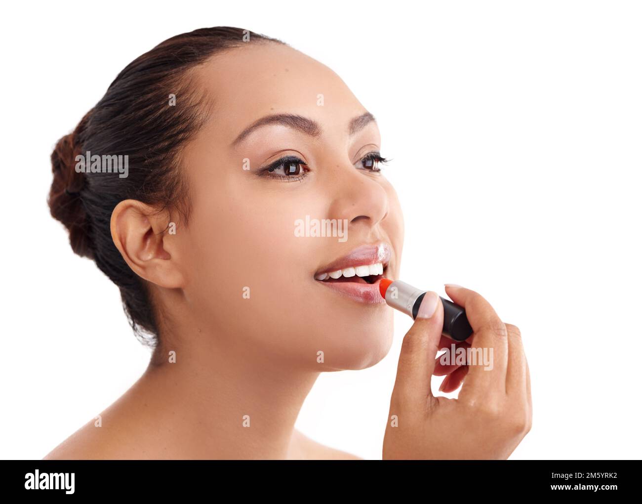 Ajouter de la couleur à ses lèvres. Photo studio d'une jeune femme en train de mettre un rouge à lèvres. Banque D'Images