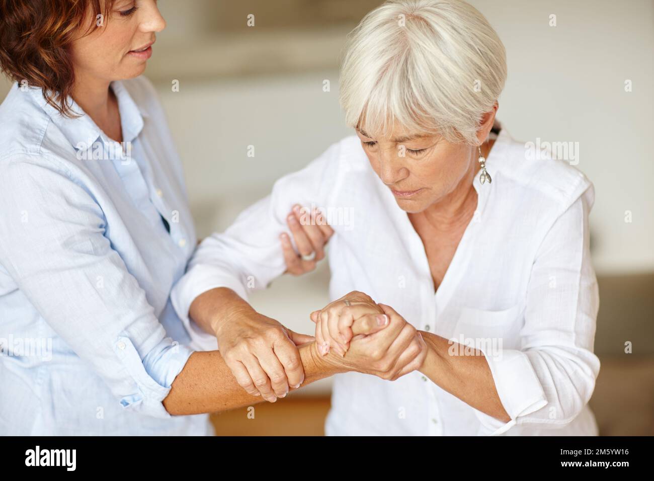 Offrir à sa mère une main d'aide. une femme qui aide sa mère âgée. Banque D'Images