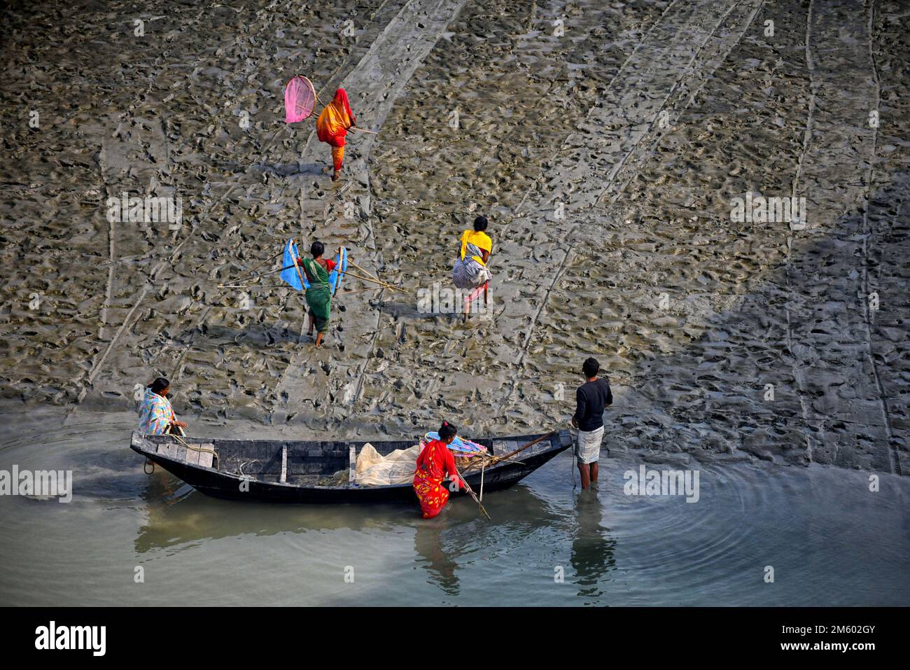 La famille des pêcheurs revient à la maison après avoir pêché sur la rivière Matla. Canning est situé près de 100 km de Kolkata et dans la région sous le delta Sunderban sur les rives occidentales de la rivière Matla. La plupart des habitants du delta sont des pêcheurs qui sont confrontés à des défis alors que l'océan envahit des terres dans la plus grande forêt de mangroves du monde, des humains et des tigres sont coincés dans un espace de plus en plus réduit dans les Sundarbans indiens, avec des conséquences mortelles. Le niveau de la mer a augmenté en moyenne de 3 à 5 centimètres par an au cours des deux dernières décennies dans les Sundarbans, ce qui a conduit à l'un des taux les plus rapides de la côte Banque D'Images