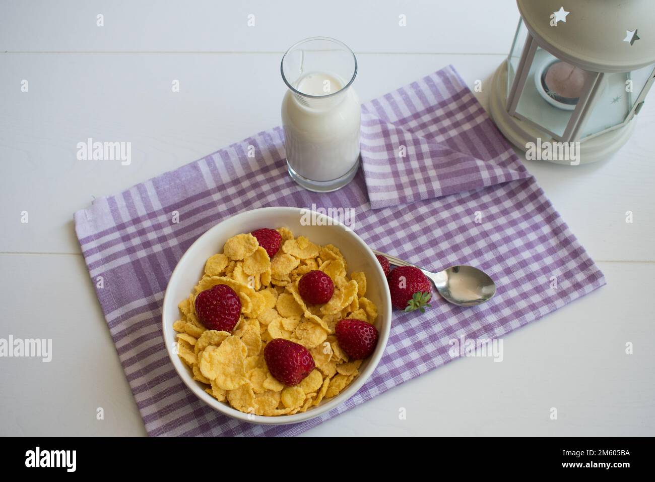 Céréales pour le petit déjeuner sain, présentation sur la table avec de délicieuses céréales, fraises, lait, vue de dessus. Banque D'Images