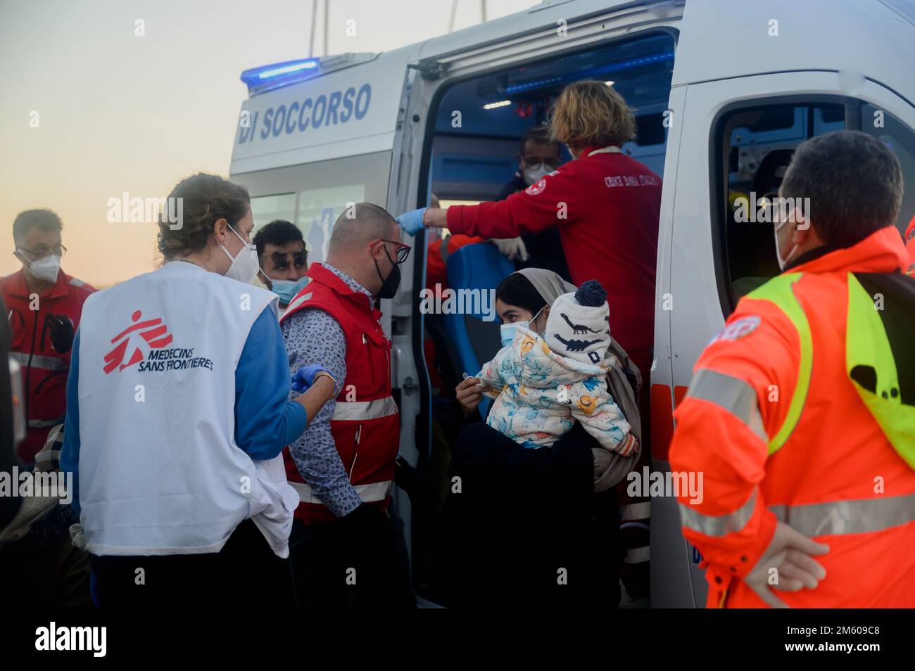 Une femme immigrante tenant un enfant vu parler avec des volontaires. Près de 90 migrants, principalement d'Afghanistan, du Pakistan et d'Iran, ont été sauvés par la Garde côtière italienne et emmenés au port de Roccella Jonica « Porto Delle Grazie ». Un bébé, né il y a trois jours pendant le passage à niveau, un nouveau-né de 11 jours et un bébé de cinq mois étaient également à bord. Des membres de la Croix-Rouge, des médecins sans frontières et du personnel sanitaire ont aidé les bébés, leurs familles et d'autres migrants. (Photo de Valeria Ferraro/SOPA Images/Sipa USA) Banque D'Images