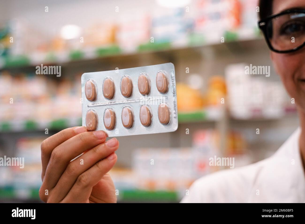 La pharmacienne montre des pilules dans des cloques dans les pharmacies Banque D'Images