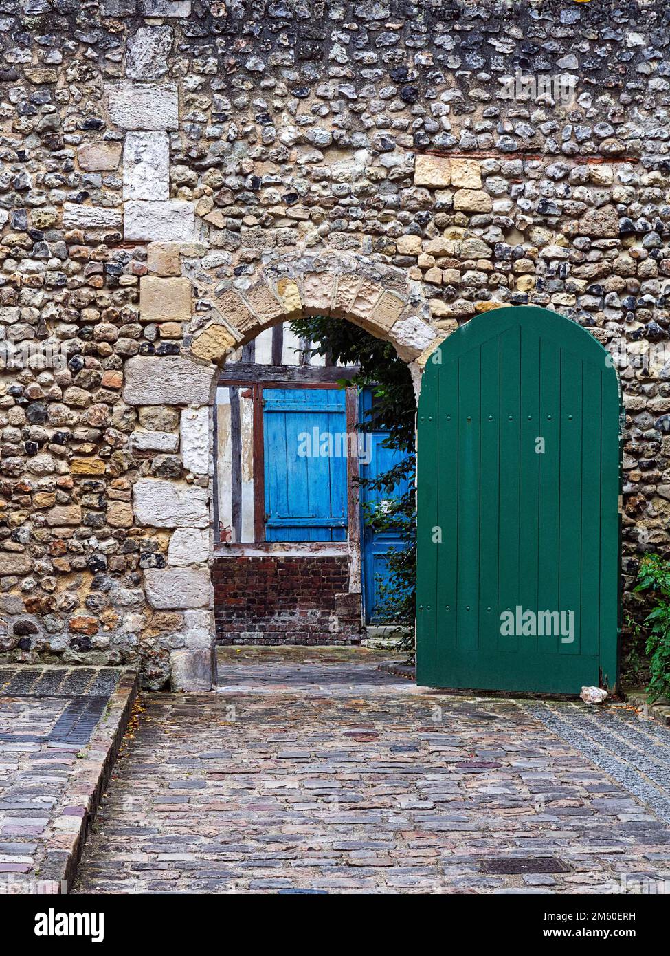 Vue par la porte verte sur maison traditionnelle en pierre avec porte bleue, Vieille ville, Honfleur, Département Calvados, Basse-Normandie, France Banque D'Images