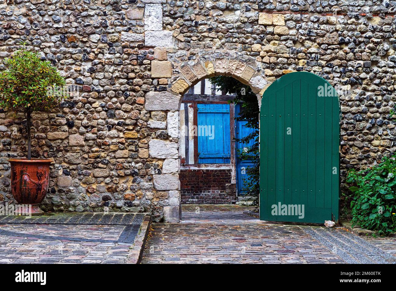 Vue par la porte verte sur maison traditionnelle en pierre avec porte bleue, Vieille ville, Honfleur, Département Calvados, Basse-Normandie, France Banque D'Images