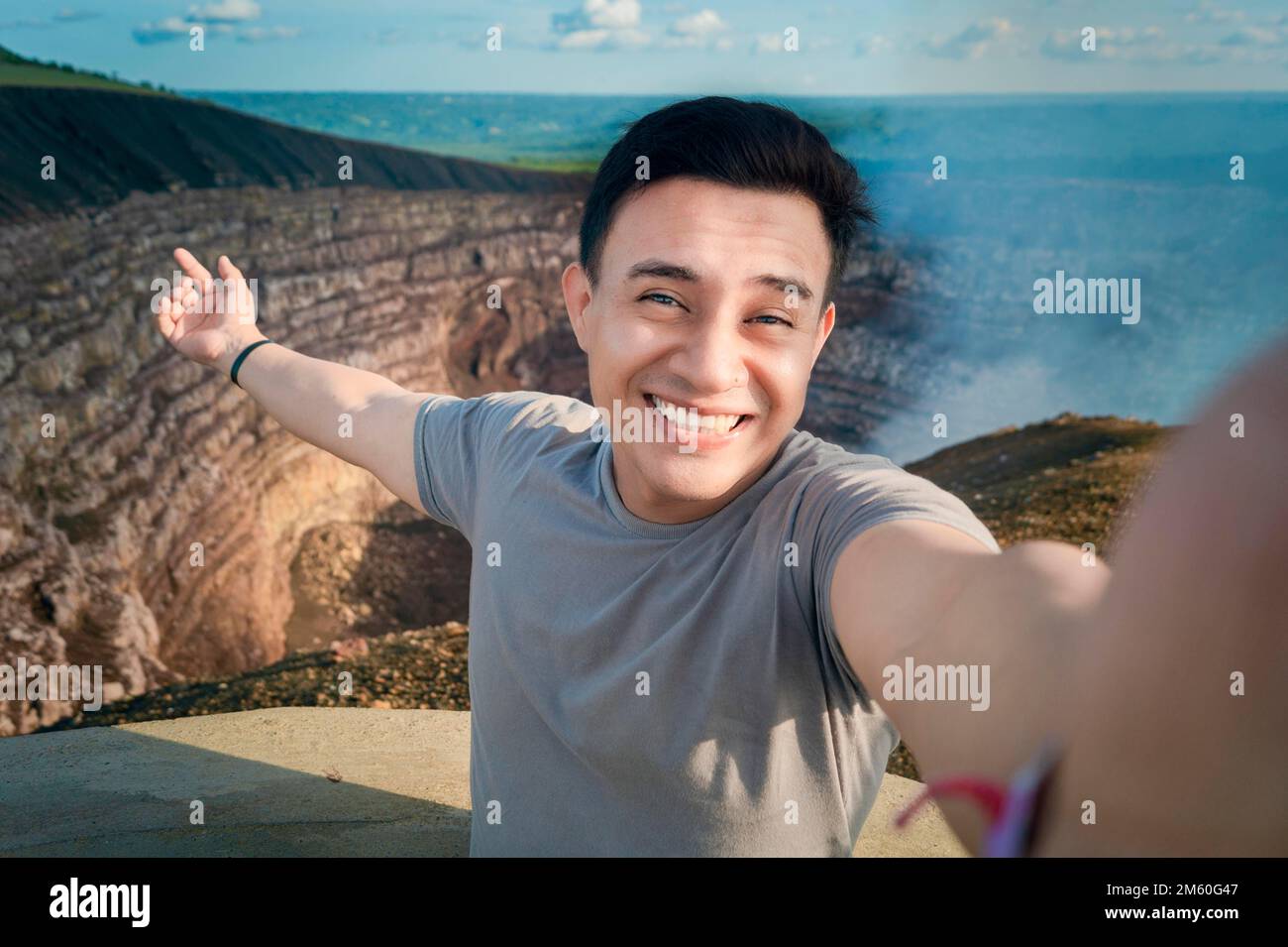 Turista haciendose un selfie en un mirador. Guapo turista tomando un selfie de vacaciones. Hombre aventurero haciendose un selfie en un mirador. Banque D'Images