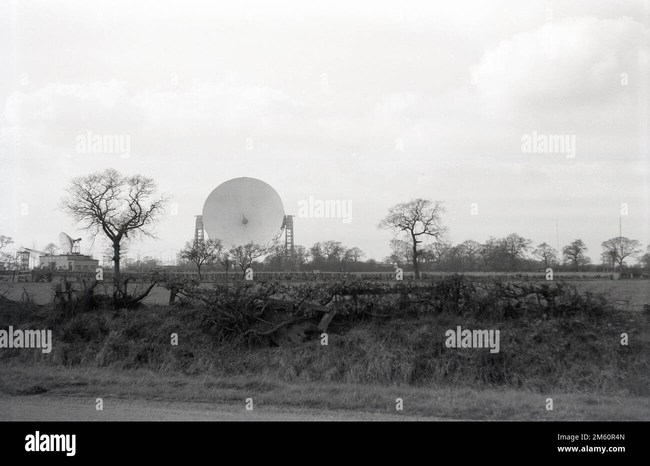 Fin 1950s, vue historique du télescope Mark i ou Lovell, Cheshire, Angleterre, Royaume-Uni, le plus grand radiotélescope parabolique du monde lors de sa construction en 1957. Le radiotélescope porte le nom de Bernard Lovell, un astronome radiophonique de l'Université de Manchester qui a établi un observatoire - l'Observatoire de la banque Jodrell - dans le nord-ouest de l'Angleterre en 1945 pour étudier les rayons cosmiques, en continu le travail qu'il avait entrepris sur le radar pendant la Seconde Guerre mondiale. En 1988, le Lovell Telescope a été construit dans un bâtiment classé de catégorie I, ce qui signifie qu'il s'agit d'un bâtiment d'un « intérêt exceptionnel ». Banque D'Images