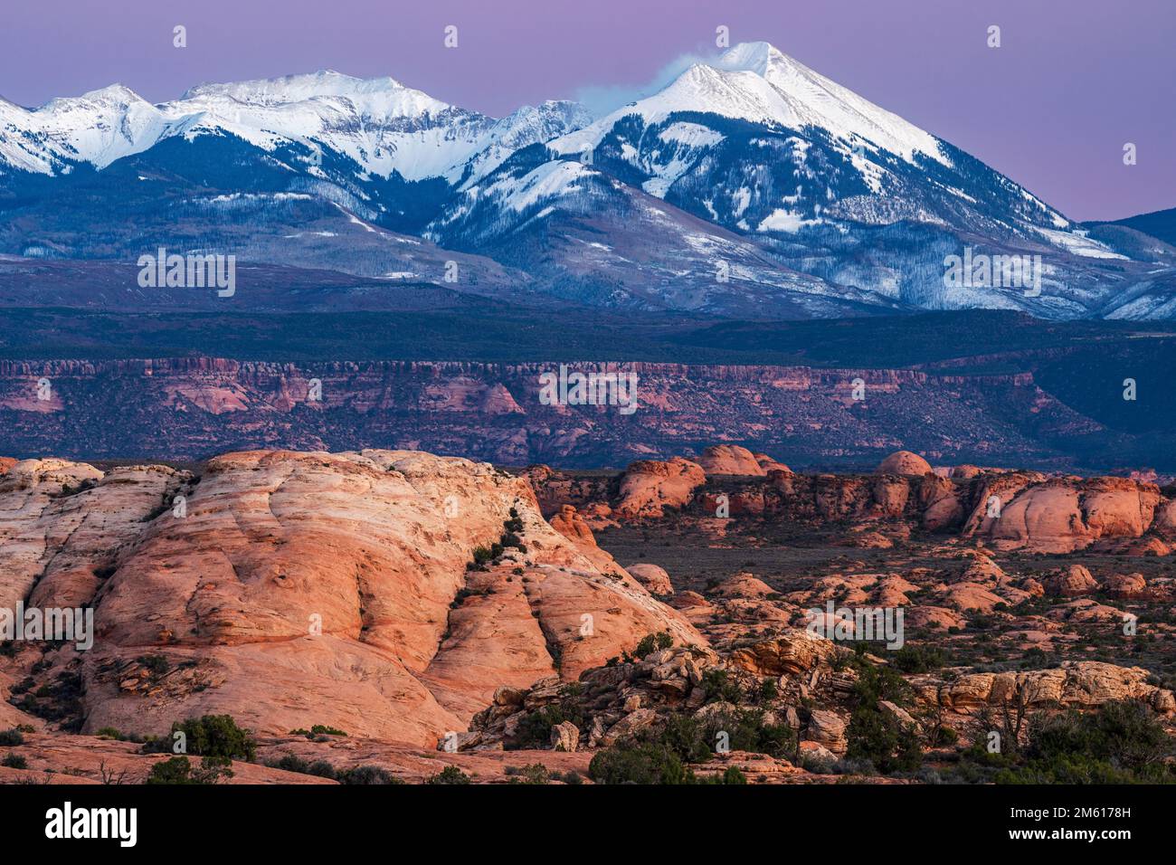 Les montagnes de la Sal ont été enneigées et les dunes pétrifiées au coucher du soleil dans le parc national d'Arches Banque D'Images