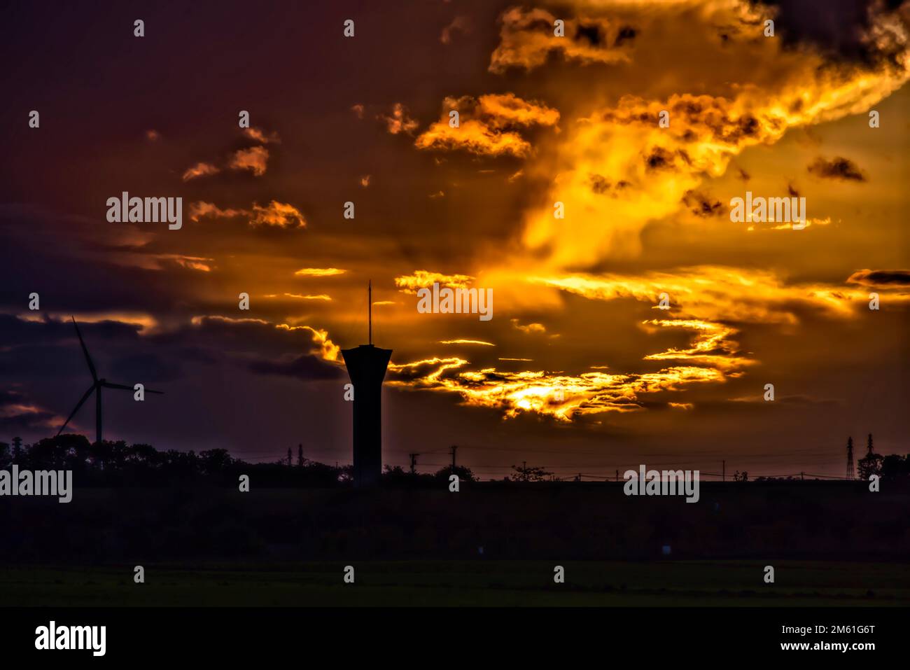 Fresnay l'eveque, France. 24th octobre 2022. Coucher de soleil sur les éoliennes et le château d'eau de 24 octobre 2022 à Fresnay l'eveque, France. Banque D'Images