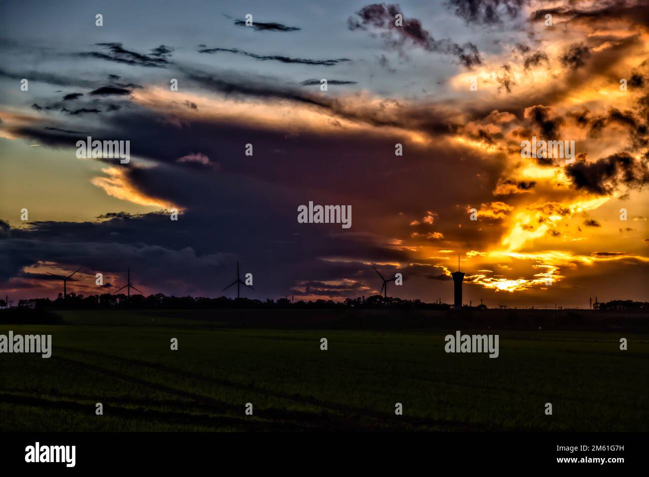 Fresnay l'eveque, France. 24th octobre 2022. Coucher de soleil sur les éoliennes et le château d'eau de 24 octobre 2022 à Fresnay l'eveque, France. Banque D'Images
