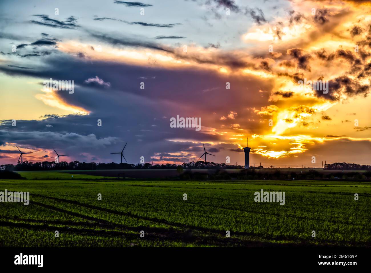Fresnay l'eveque, France. 24th octobre 2022. Coucher de soleil sur les éoliennes et le château d'eau de 24 octobre 2022 à Fresnay l'eveque, France. Banque D'Images