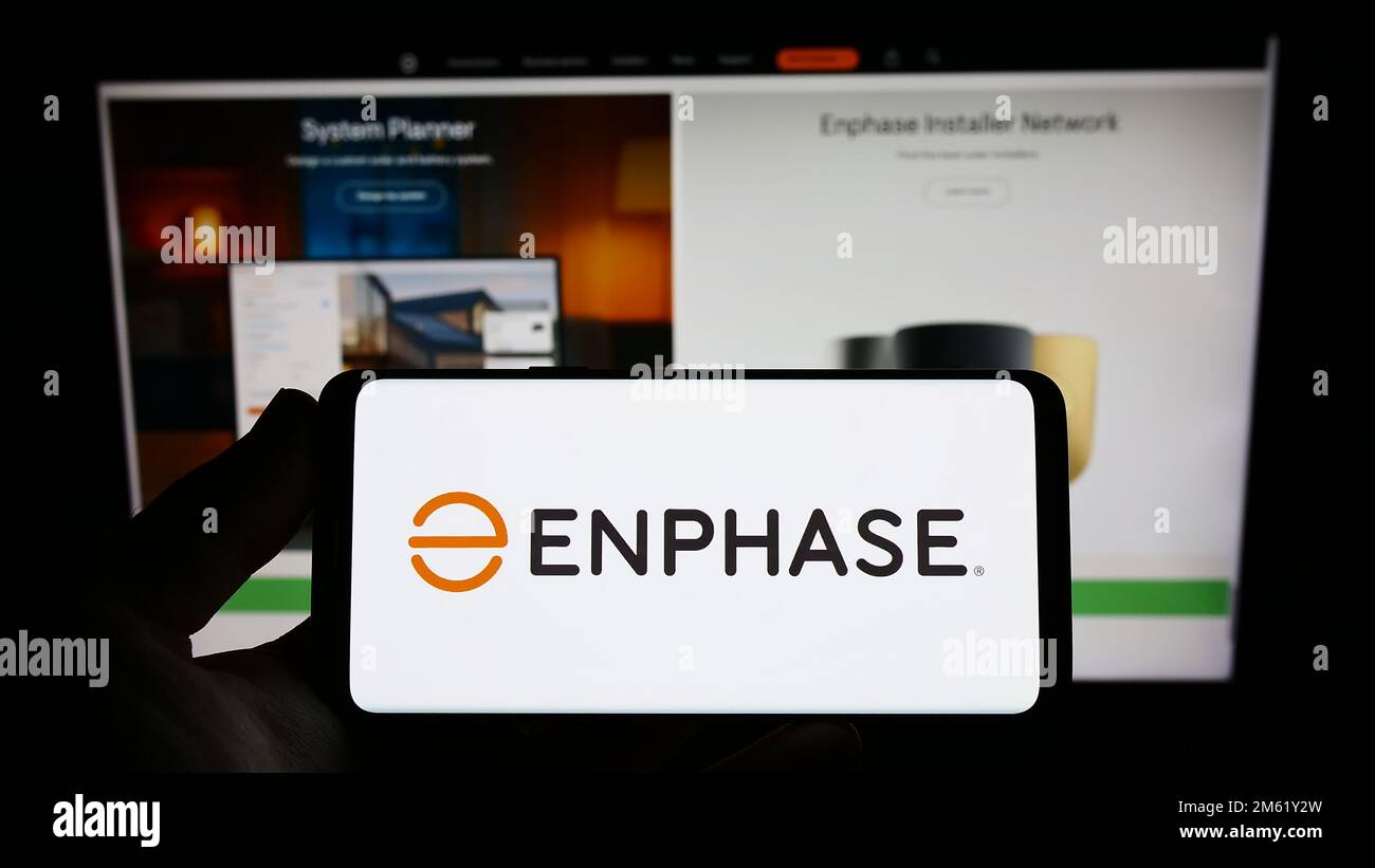 Personne tenant un smartphone avec le logo de la société américaine Enphase Energy Inc. À l'écran devant le site Web. Mise au point sur l'affichage du téléphone. Banque D'Images
