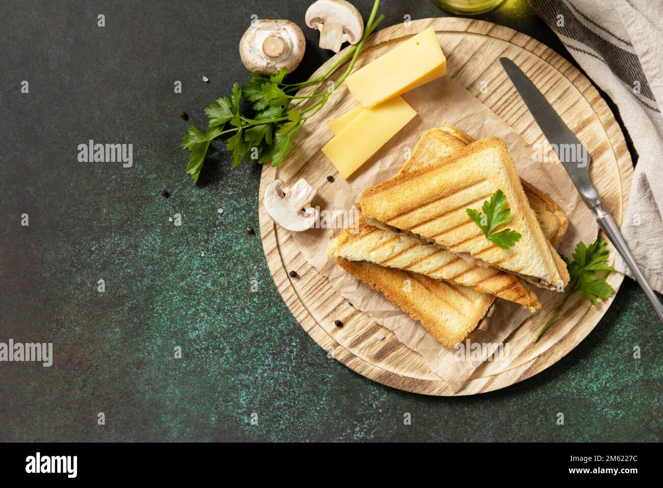 Délicieux sandwich au fromage grillé, au bacon et aux champignons. Petit-déjeuner fait maison sur une table en pierre sombre. Vue de dessus. Copier l'espace. Banque D'Images