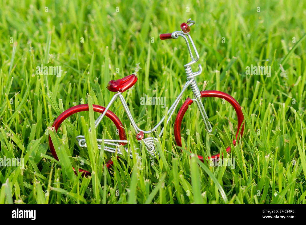 mini vélo jouet rouge sur l'herbe. Banque D'Images
