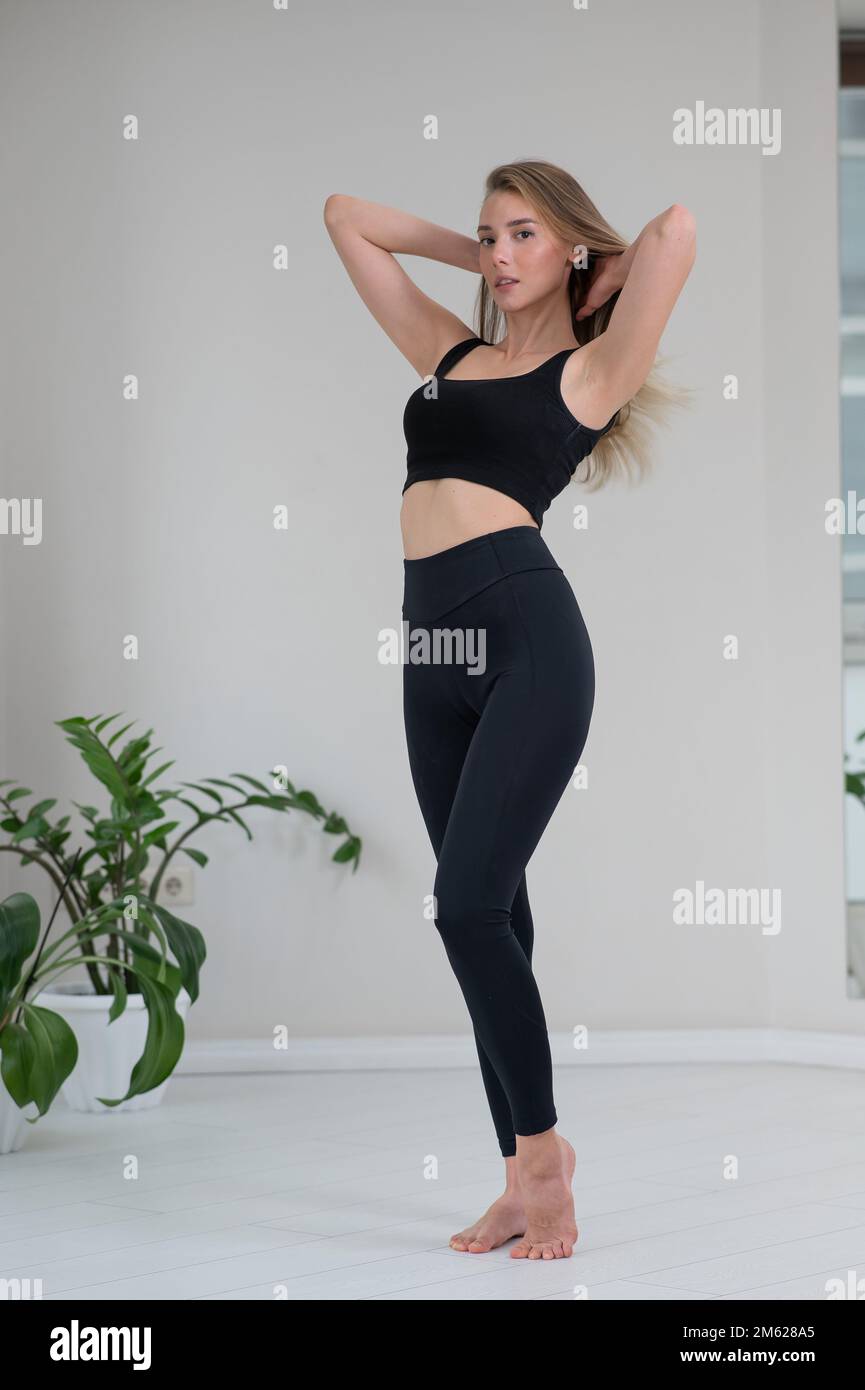 Portrait complet d'une belle femme caucasienne en vêtements de sport noirs. Banque D'Images Portrait complet d'une belle femme caucasienne en vêtements de sport noirs. Banque D'Images