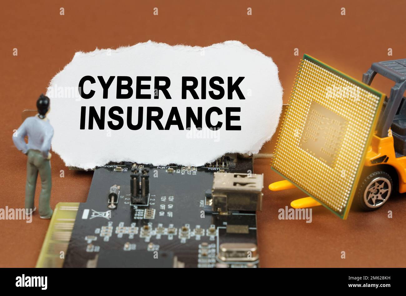 Concept informatique. Sur la carte avec microcircuits se trouve une plaque en papier avec l'inscription - Cyber Risk Insurance. À proximité se trouve un chargeur de jouets avec un cortège Banque D'Images